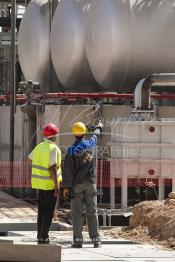 Image du Maroc Professionnelle de  Des ouvriers de STROC Industrie s'activent dans la construction de la Cimenterie Ait Baha à Agadir, Mardi 22 Juin 2010. STROC est une société marocaine qui exerce son métier dans le domaine de l’ingénierie d’exécution pour les industries de procédé, les réalisations à son actif l’ont conduit à développer une expertise et un savoir-faire fort dans la construction ainsi que dans différents métiers afin d'offrir des solutions clé en main pour satisfaire au mieux ses clients. Parmi ces réalisations ont trouve : des unités de stockage et de traitement de produits liquides ou gazeux, installations de manutention et de traitement de produits en vrac ainsi que dans les domaines de Ingénierie Etudes, Génie Civil, Chaudronnerie, Structure Métallique, Tuyauterie, Montage, Maintenance, Bâtiments industriels, Logistiques, Tertiaires et Ouvrages d’Art. (Photo / Abdeljalil Bounhar)